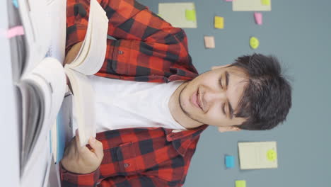 Vertical-video-of-Happy-male-student-reading-a-book.